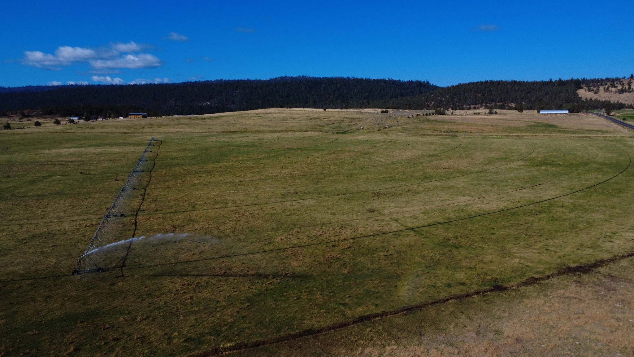 Center-pivot irrigation system extending across a ranch field